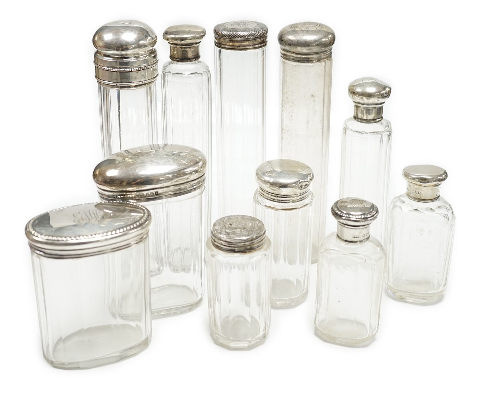 Forty four assorted silver or white metal mounted glass toilet bottles, tallest 18cm, a quantity of similar toilet jar lids and three base metal mounted glass toilet jars.